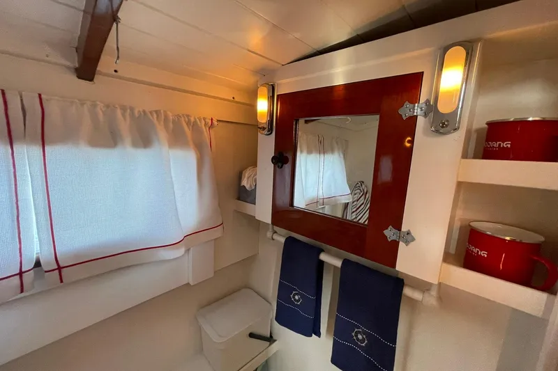 Slide: The Image of Vintage 1939 Richardson boat interior with mirror, curtains, and red mugs on shelves. - 18