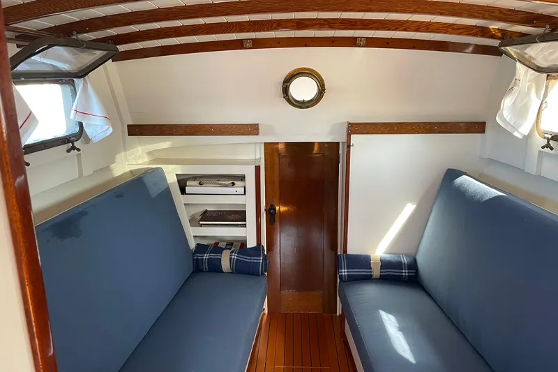 Slide: The Image of Interior of 1939 Richardson 26 Little Giant boat with blue seating and wooden accents. - 2