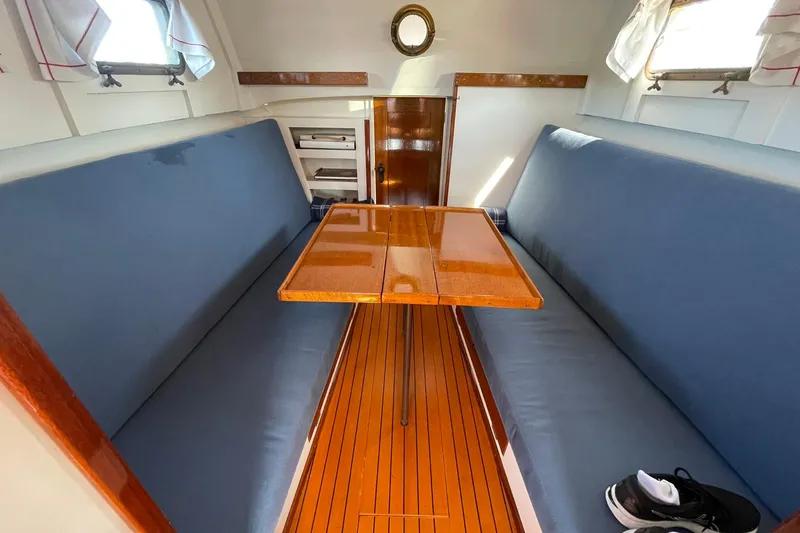 Slide: The Image of Interior of 1939 Richardson 26 Little Giant boat with wooden table and blue seating. - 24