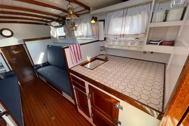Slide: The Image of 1939 Richardson 26 Little Giant boat interior with wooden accents and cozy seating. - 3