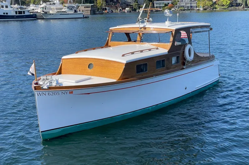 Slide: The Image of 1939 Richardson 26 Little Giant boat on water, classic wooden design, serene marina backdrop. - 49