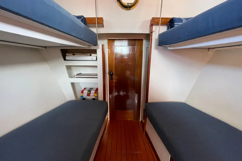 Slide: The Image of Interior of 1939 Richardson 26 Little Giant boat with wooden flooring and bunk beds. - 6