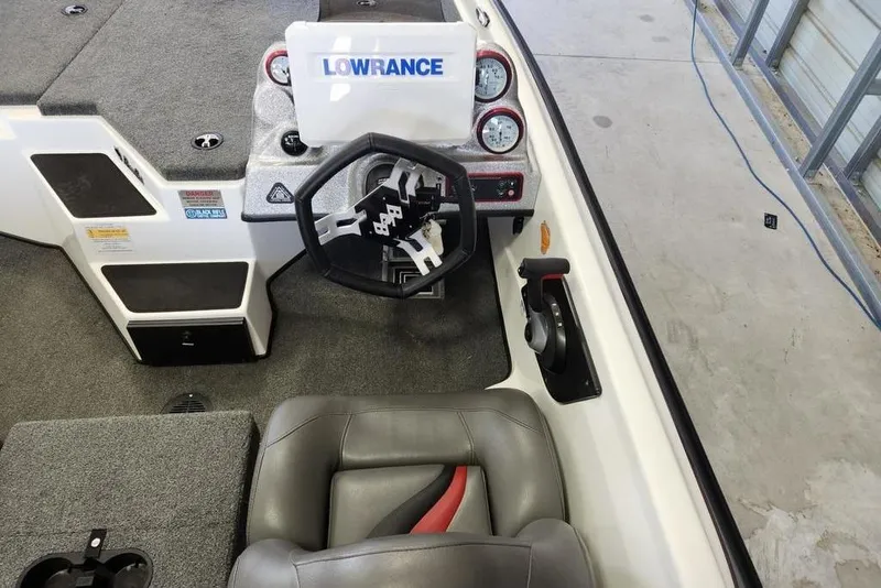 Slide: The Image of 2023 Bass Cat Bobcat boat interior with steering wheel and Lowrance electronics. - 2