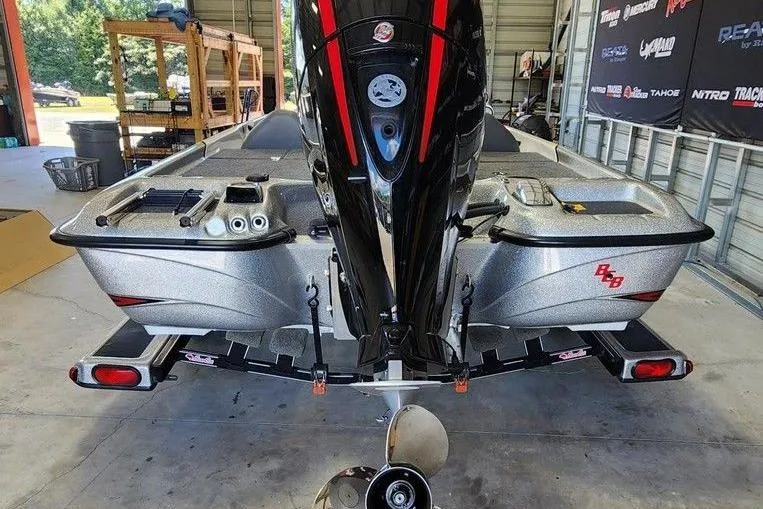 Slide: The Image of 2023 Bass Cat Bobcat boat in a garage, showcasing rear view and motor. - 3