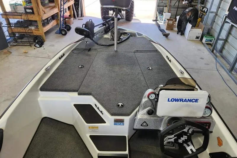 Slide: The Image of 2023 Bass Cat Bobcat boat interior with Lowrance electronics in a garage setting. - 4