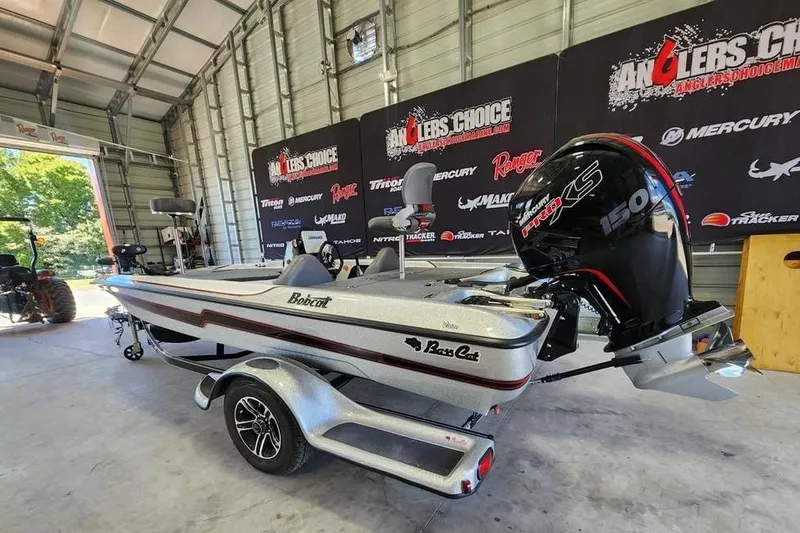 Slide: The Image of 2023 Bass Cat Bobcat boat in a garage, featuring a powerful Mercury engine. - 5