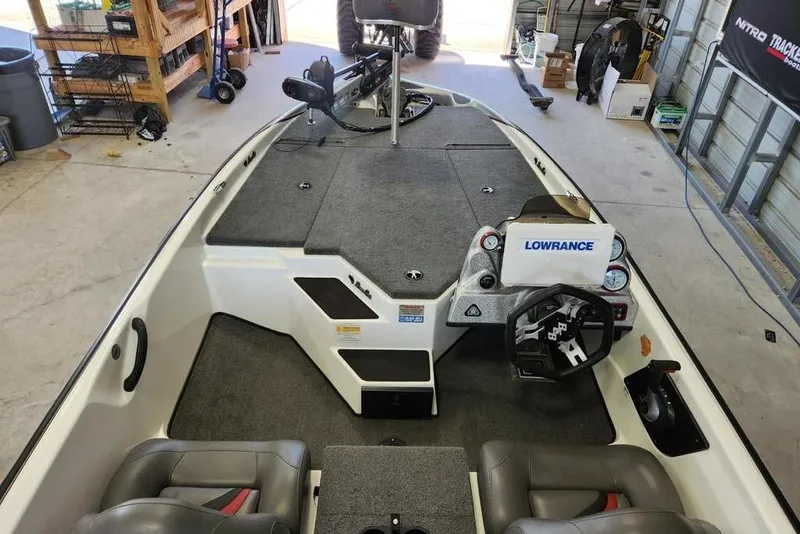 Slide: The Image of 2023 Bass Cat Bobcat boat interior with Lowrance electronics in a garage setting. - 6