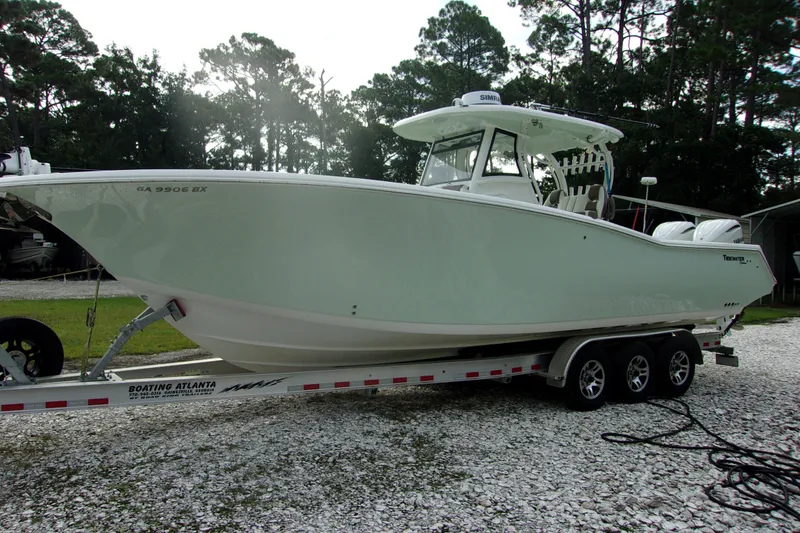 The Image of 2025 Tidewater 320 CC Adventure boat on trailer, parked outdoors. - 1
