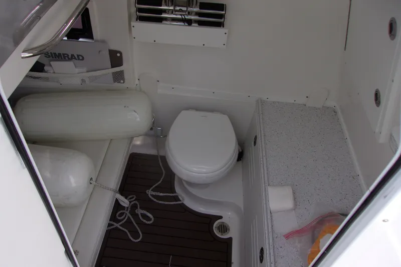 Slide: The Image of 2025 Tidewater 320 CC Adventure boat interior with toilet and storage area. - 20