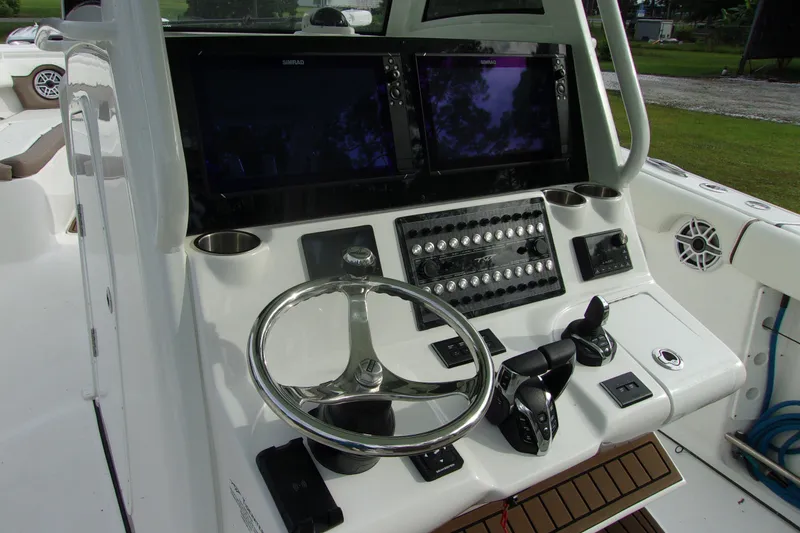 Slide: The Image of 2025 Tidewater 320 CC Adventure boat dashboard with dual screens and controls. - 32