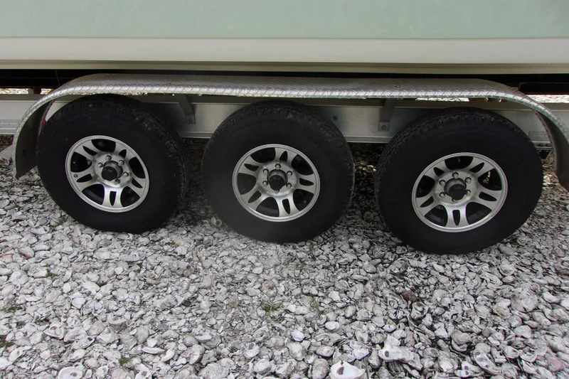 Slide: The Image of Triple-axle trailer for 2025 Tidewater 320 CC Adventure on gravel surface. - 44