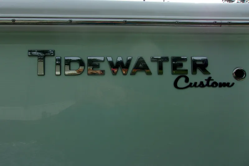 Slide: The Image of 2025 Tidewater 320 CC Adventure boat logo on hull, featuring "Tidewater Custom" text. - 65