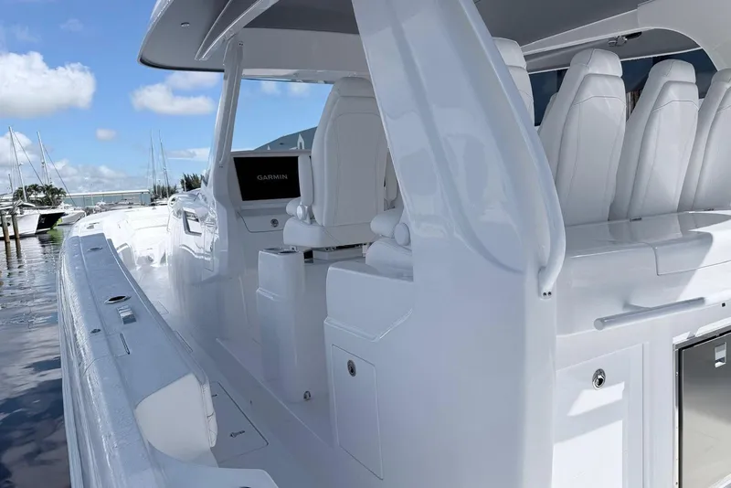 Slide: The Image of 2025 Intrepid 51 Panacea luxury boat interior with white seating and Garmin navigation system. - 13