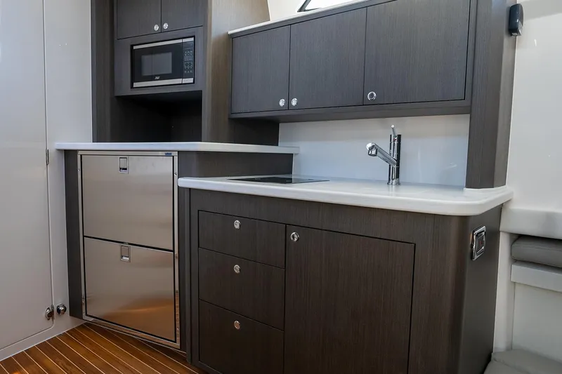 Slide: The Image of Manufacturer Provided Image: Modern kitchen area in 2025 Intrepid 51 Panacea yacht with sleek cabinetry and stainless steel appliances. - 25