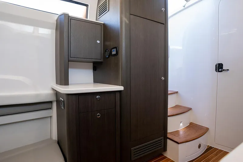 Slide: The Image of Manufacturer Provided Image: 2025 Intrepid 51 Panacea interior with wooden cabinetry and stairs. - 26