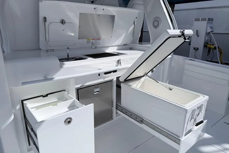 Slide: The Image of 2025 Intrepid 51 Panacea yacht kitchen with sleek white cabinetry and modern appliances. - 5
