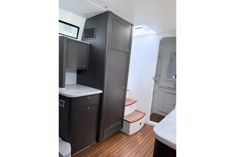 Slide: The Image of Interior of 2025 Intrepid 51 Panacea yacht with modern cabinetry and wooden flooring. - 9