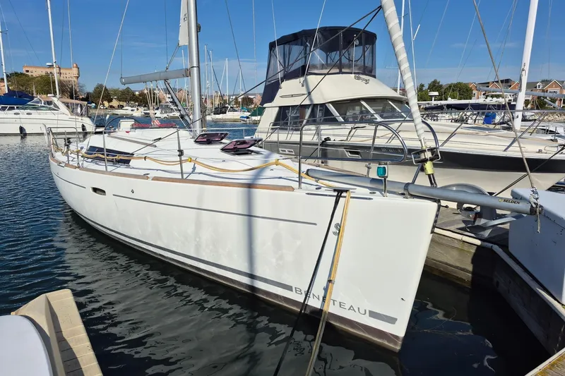 Slide: The Image of 2011 Beneteau Oceanis 37 sailboat docked in a marina, surrounded by other boats. - 1