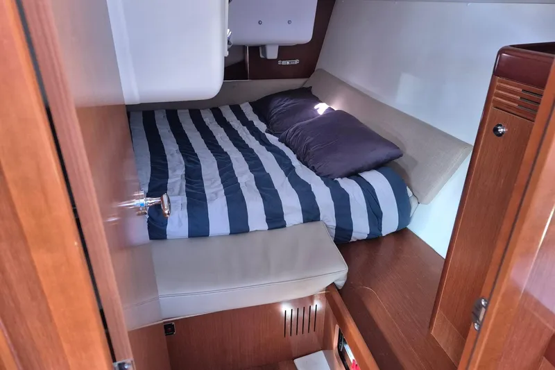Slide: The Image of Cozy cabin interior of 2011 Beneteau Oceanis 37 sailboat with striped bedding. - 19