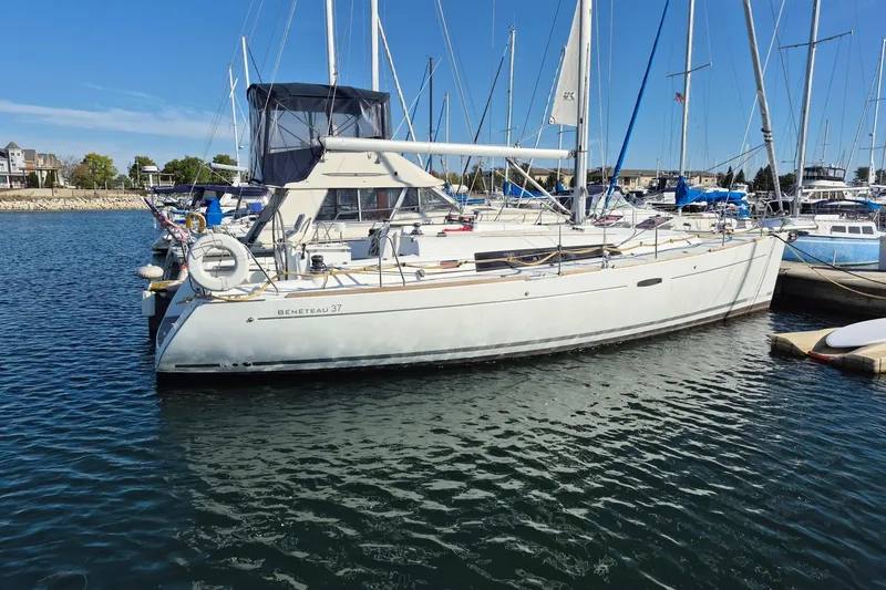 Slide: The Image of 2011 Beneteau Oceanis 37 sailboat docked in a marina under clear blue skies. - 2