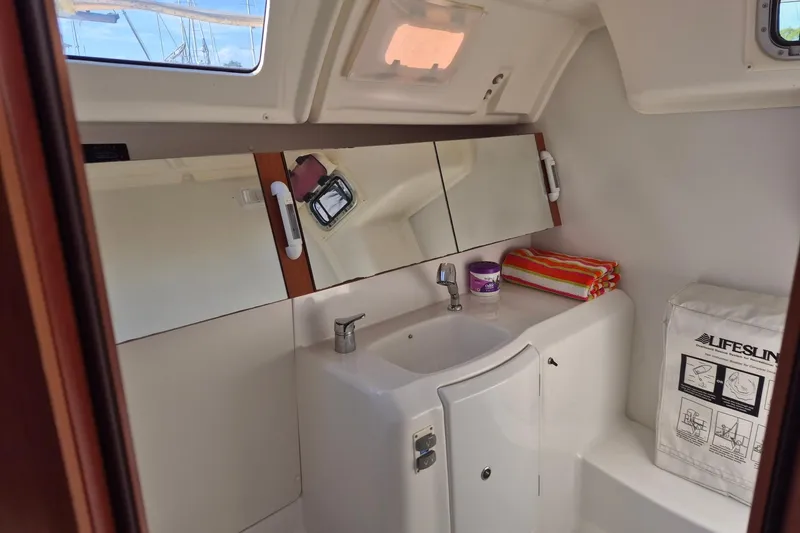 Slide: The Image of Beneteau Oceanis 37 bathroom interior, featuring a sink, mirror, and storage, 2011 model. - 23