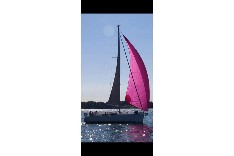 Slide: The Image of Sailing yacht Beneteau Oceanis 37 (2011) with vibrant pink sail on calm water. - 39