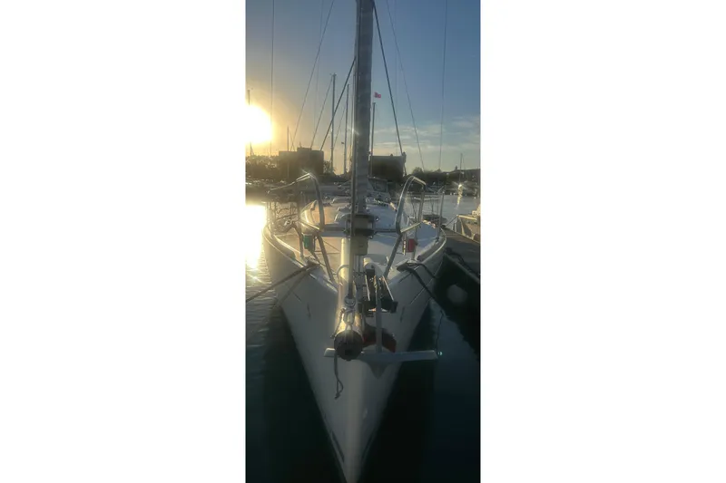 Slide: The Image of 2011 Beneteau Oceanis 37 sailboat docked at sunset, reflecting on water. - 41