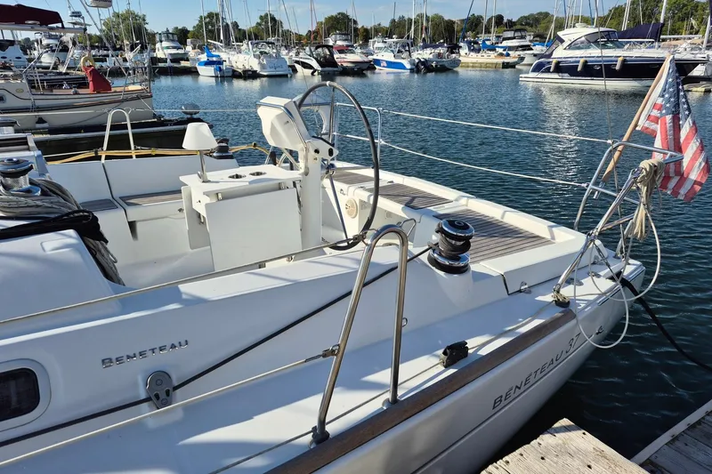 Slide: The Image of 2011 Beneteau Oceanis 37 sailboat docked in a marina, featuring sleek design and American flag. - 7