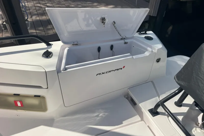 Slide: The Image of 2021 Axopar 37 Cross Cabin storage compartment with open lid on deck. - 16