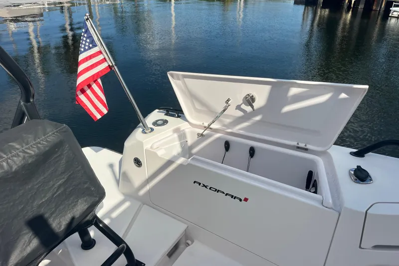 Slide: The Image of 2021 Axopar 37 Cross Cabin boat with open storage and American flag. - 17