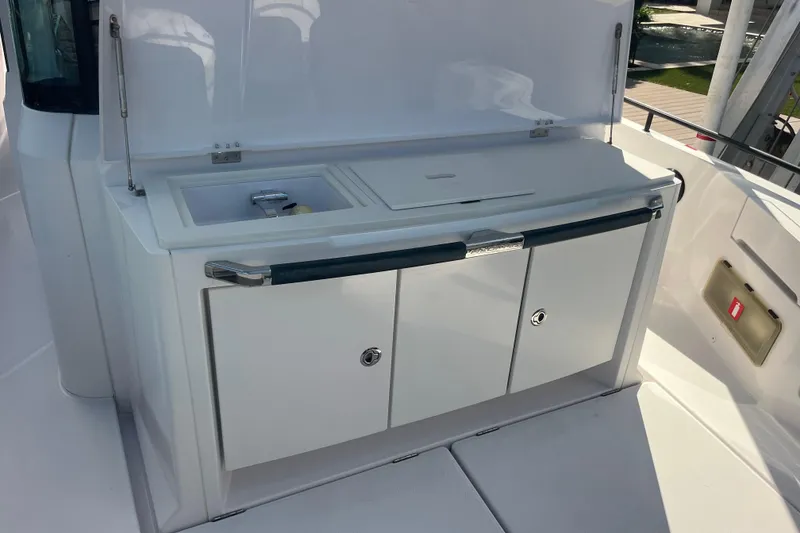 Slide: The Image of 2021 Axopar 37 Cross Cabin boat kitchenette with sink and storage cabinets. - 19