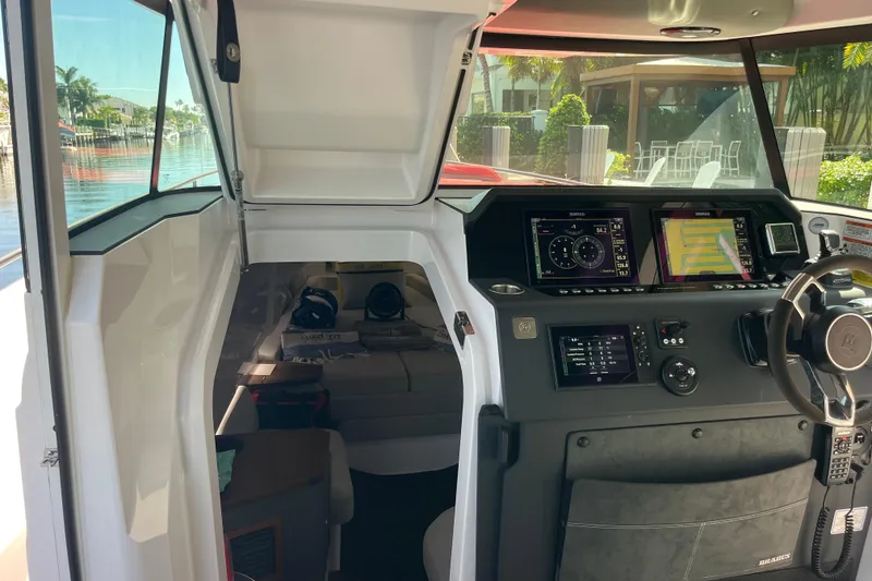 Slide: The Image of 2021 Axopar 37 Cross Cabin interior with navigation displays and steering wheel. - 23