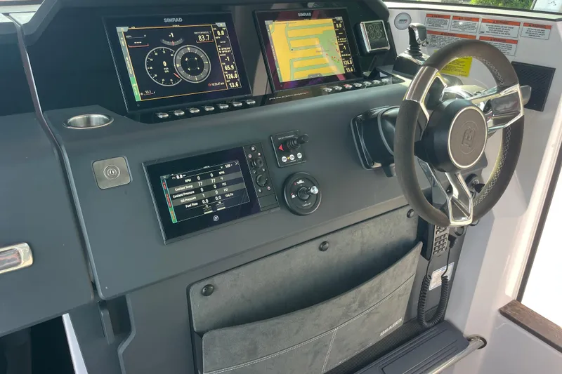 Slide: The Image of 2021 Axopar 37 Cross Cabin dashboard with Simrad displays and modern steering wheel. - 31