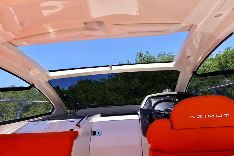 Slide: The Image of Interior view of 2014 Azimut 38 yacht cockpit with red seats and open sunroof. - 14