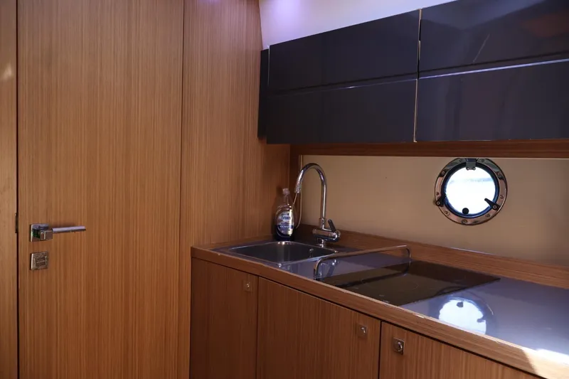 Slide: The Image of Luxurious kitchen interior of 2014 Azimut 38 yacht with sleek wood finish and porthole. - 17