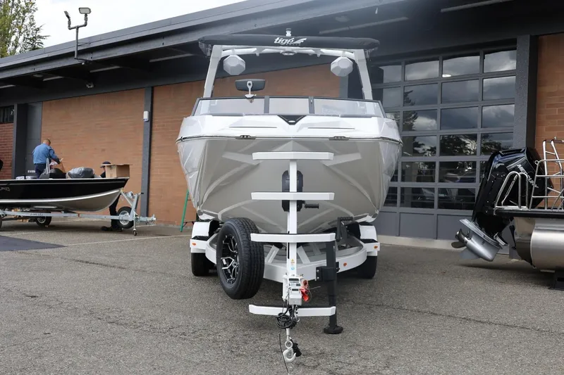 Slide: The Image of 2026 Tigé 22RZX boat on trailer outside a garage, ready for transport. - 6