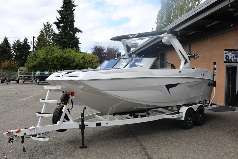 Slide: The Image of 2026 Tigé 22RZX boat on trailer, parked outside a building. - 7