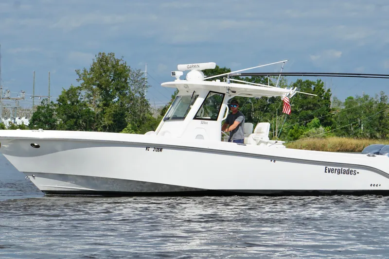 Slide: The Image of 2012 Everglades 325 Center Console boat cruising on a calm waterway. - 10