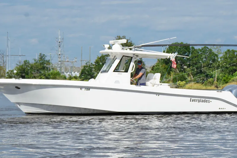 Slide: The Image of 2012 Everglades 325 Center Console boat cruising on a calm waterway. - 12