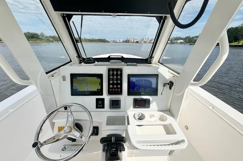 Slide: The Image of 2012 Everglades 325 Center Console boat interior with navigation screens and steering wheel. - 14