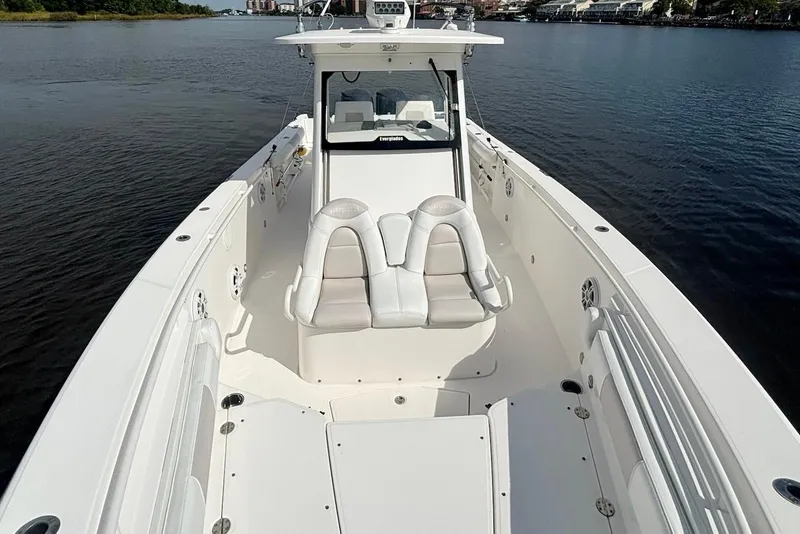 Slide: The Image of 2012 Everglades 325 Center Console boat on calm water, showcasing spacious deck and seating. - 17