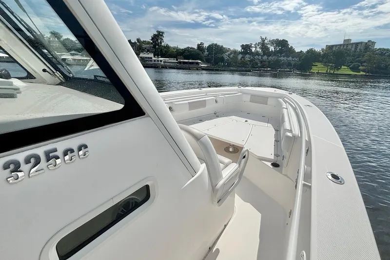 Slide: The Image of 2012 Everglades 325 Center Console boat on calm water, showcasing sleek design and spacious deck. - 18