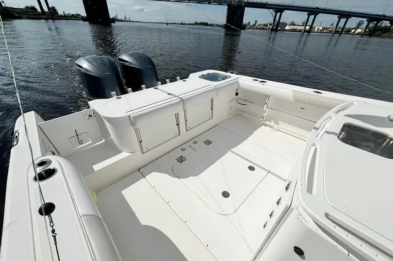 Slide: The Image of 2012 Everglades 325 Center Console boat with spacious deck and dual engines on calm water. - 19