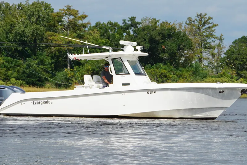 Slide: The Image of 2012 Everglades 325 Center Console boat cruising on a calm river. - 3