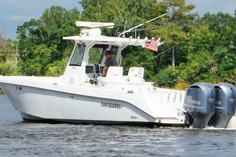 Slide: The Image of 2012 Everglades 325 Center Console boat cruising on a river with twin Yamaha engines. - 7
