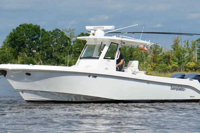 Slide: The Image of 2012 Everglades 325 Center Console boat on water, with trees in the background. - 8