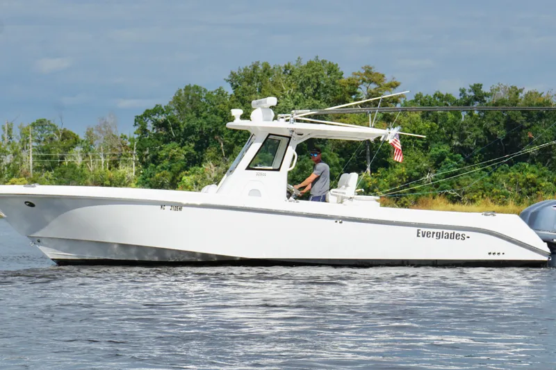 Slide: The Image of 2012 Everglades 325 Center Console boat cruising on a calm river. - 9