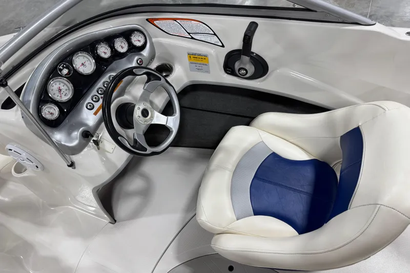 Slide: The Image of 2009 Tahoe Q5i boat cockpit with steering wheel, gauges, and cushioned seat. - 11
