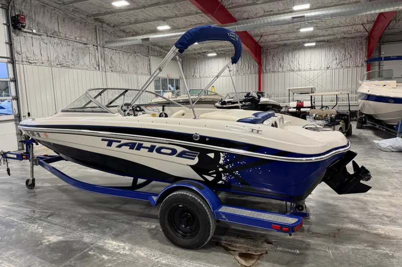 Slide: The Image of 2009 Tahoe Q5i boat in a warehouse, blue and white design, on a trailer. - 4
