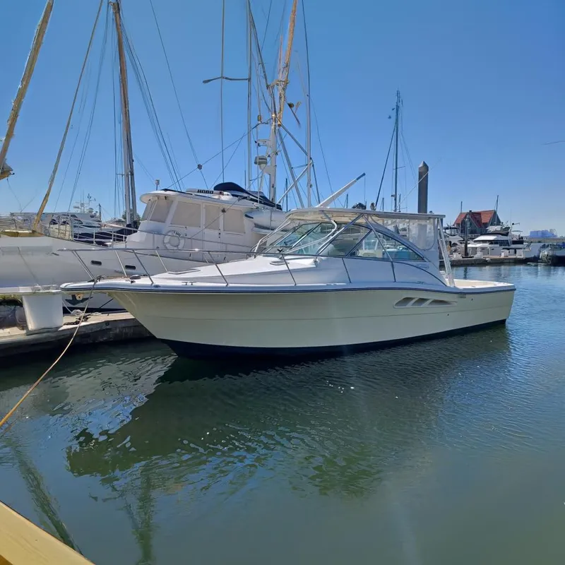 The Image of 2006 Rampage 33 Express boat docked at a marina, surrounded by other vessels. - 0
